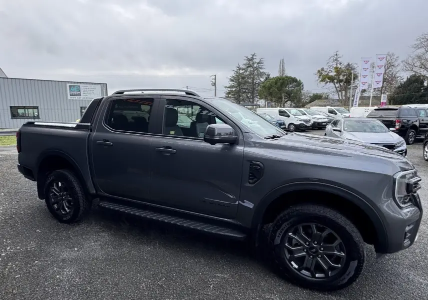 Vue latérale droite du Ford Ranger gris foncé 2025 avec cabine double et jantes alliage noires.