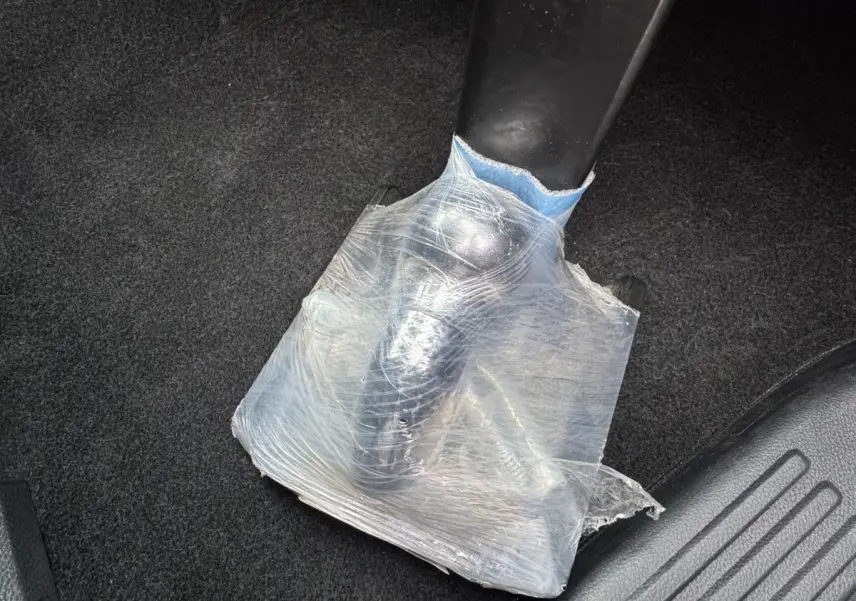Détail du frein à main noir partiellement protégé par un film plastique transparent dans un Ford Ranger 2025.