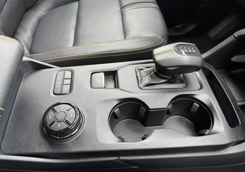 Vue rapprochée de la console centrale noire du Ford Ranger 2025 avec levier de vitesse automatique et molette de modes de conduite.