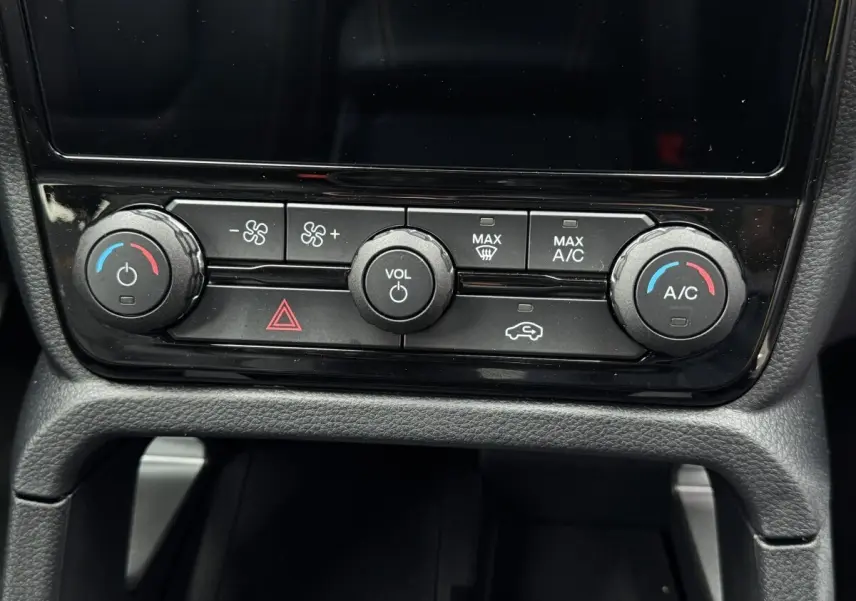 Gros plan sur la console centrale noire du Ford Ranger 2025, avec commandes de climatisation et volume.