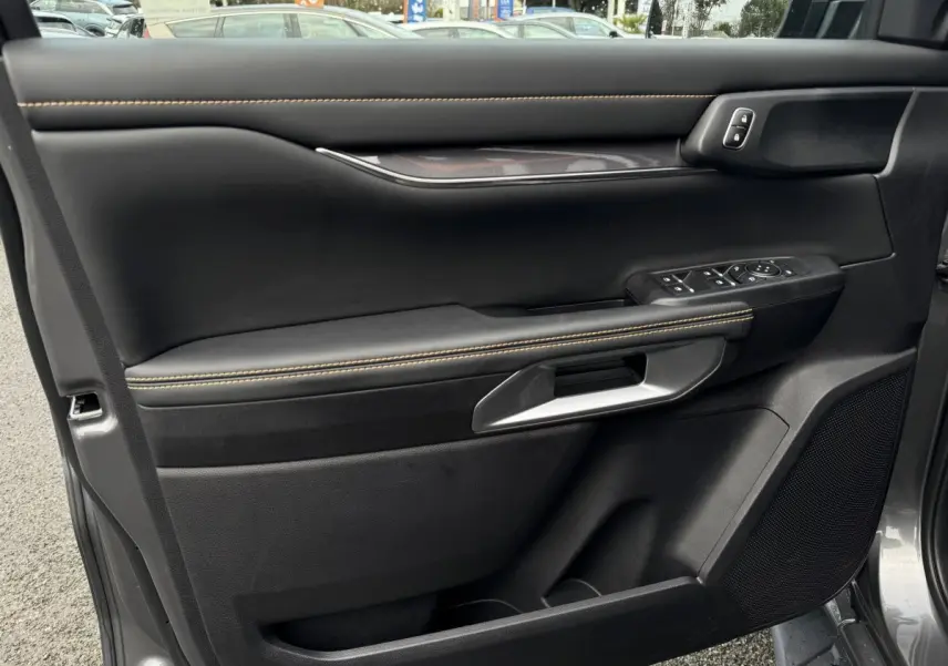 Vue intérieure côté gauche de la porte avant d’un Ford Ranger 2025 avec garniture noire et surpiqûres jaunes.