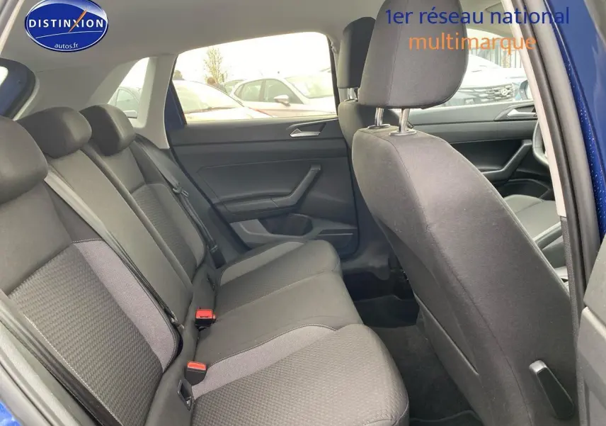 Vue intérieure côté arrière droit de la Volkswagen Polo 1.0 TSI 95 VW Edition bleu récif, montrant les sièges arrière en tissu noir.