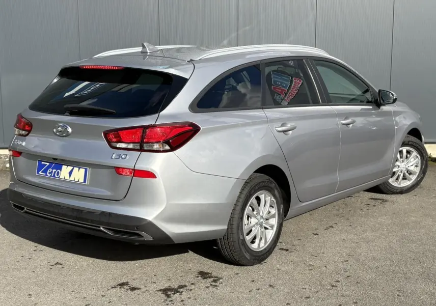 Vue 3/4 arrière droite d'une Hyundai i30 SW T-GDI 120 Modern gris argent avec jantes alliage et vitres arrière surteintées.