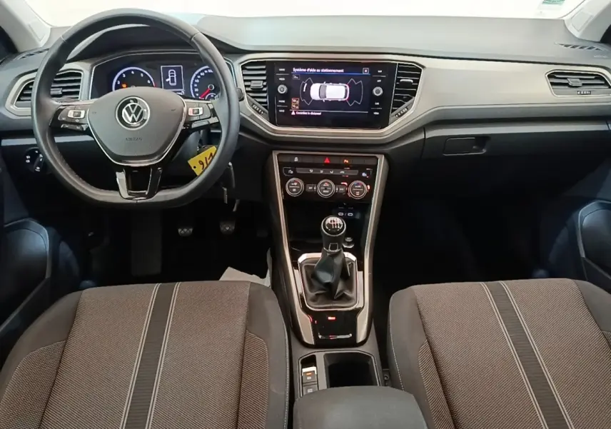 Vue intérieure frontale du Volkswagen T-Roc 1.5 TSI 2020, tableau de bord noir avec écran tactile et boîte manuelle.