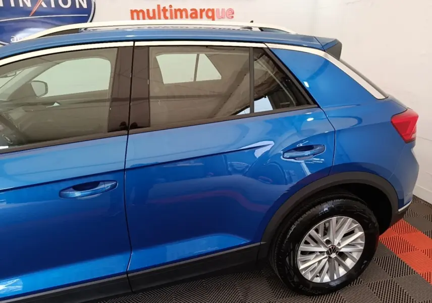 Vue latérale côté droit d'un Volkswagen T-Roc bleu 2020 avec toit blanc et jantes alliage.