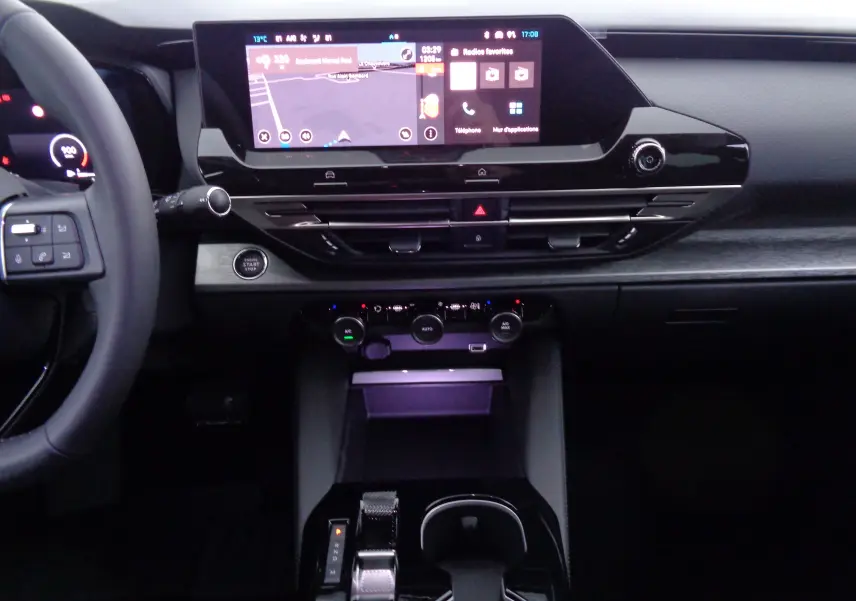 Intérieur du Citroën C5 X 2023 en noir métal, vue centrée sur la console avec écran tactile et commandes de climatisation.