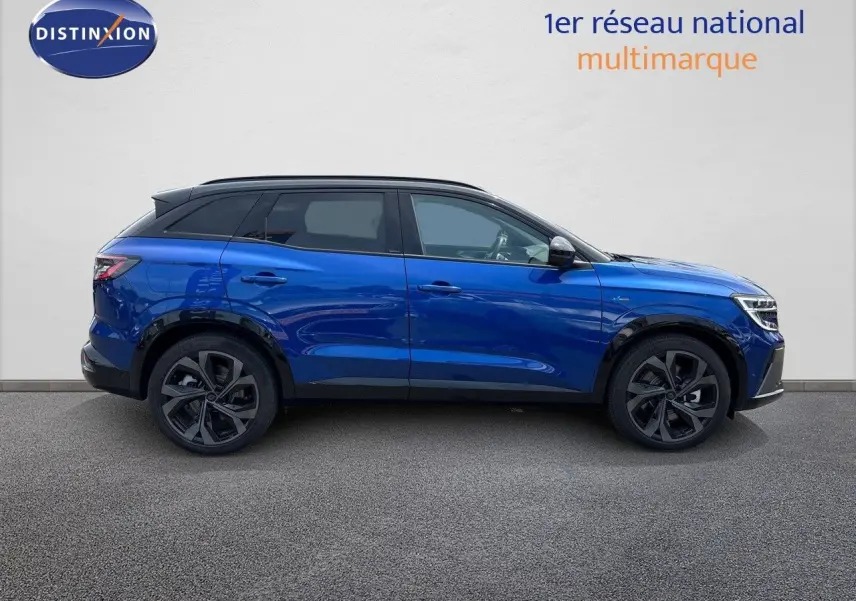 Profil droit d'un Renault Austral E-Tech hybride bleu Iron Metal avec toit noir, soulignant ses jantes noires et lignes modernes.
