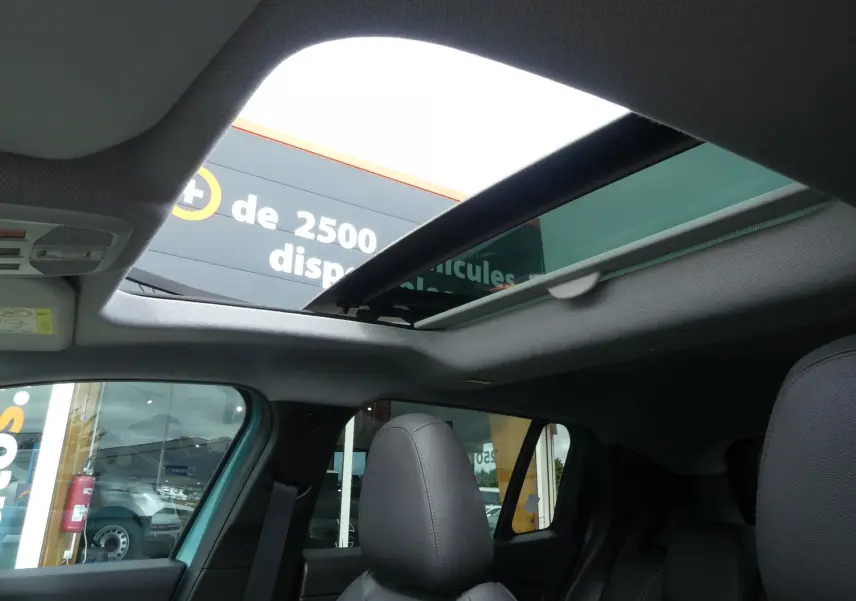 Toit ouvrant électrique en verre vu de l'intérieur avant du Jeep Avenger bleu métallisé 2024.