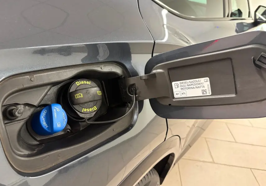 Gros plan sur la trappe à carburant côté gauche d'un CUPRA Formentor gris magnétique avec bouchons Diesel et AdBlue visibles.