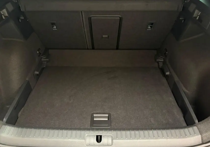 Coffre spacieux et vide du CUPRA Formentor gris magnétique, vue de l'arrière avec plancher plat et finitions noires.