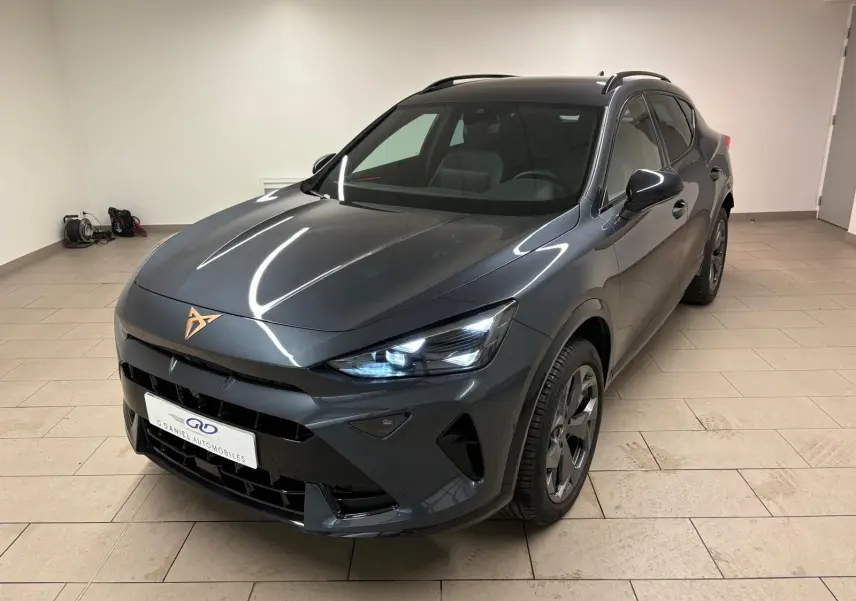 Vue 3/4 avant droit du CUPRA Formentor gris magnétique avec phares allumés et logo cuivré sur le capot.