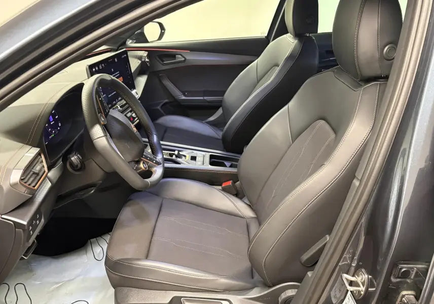 Vue intérieure côté conducteur du CUPRA Formentor gris magnétique, avec sièges en cuir noir et tableau de bord moderne.