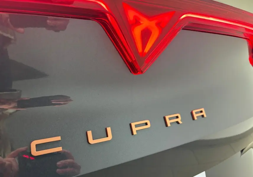 Gros plan sur le logo et le nom CUPRA en cuivre sur la malle arrière gris magnétique du Formentor 2025.
