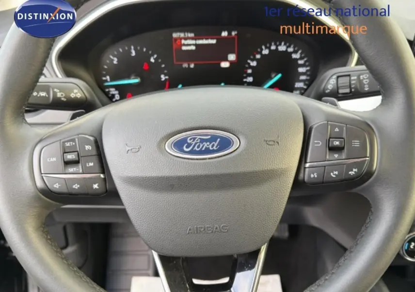 Volant Ford Focus SW 2019 en gros plan, avec commandes intégrées et tableau de bord numérique visible en arrière-plan.