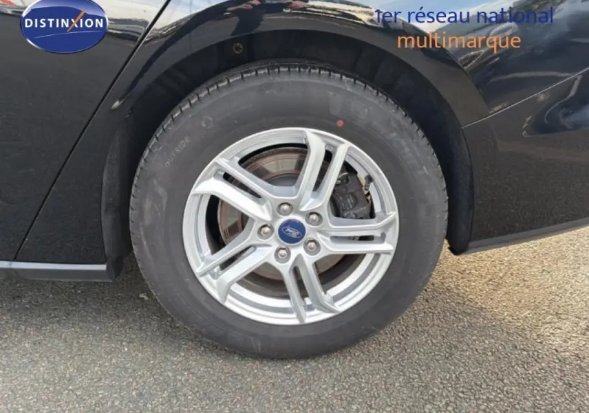 Gros plan sur la roue avant gauche en alliage argenté d'une Ford Focus SW noire de 2019.