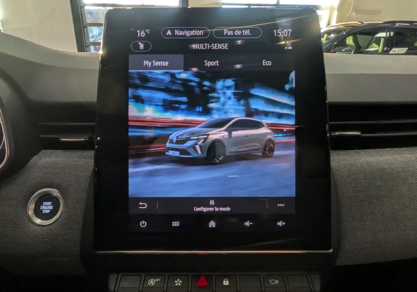 Écran tactile central affichant la Renault Clio V grise en vue 3/4 avant dans l'interface Multi-Sense du tableau de bord.