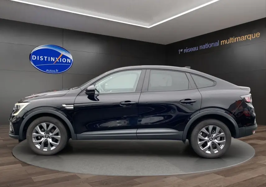 Profil côté gauche du Renault Arkana noir 2024, version TCE 140 EDC Evolution, sur fond intérieur showroom.
