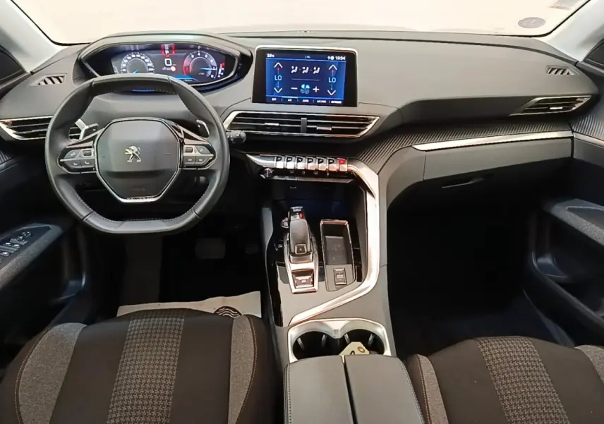 Vue intérieure avant du Peugeot 3008 2022 noir, tableau de bord moderne avec écran tactile central et volant multifonctions cuir.