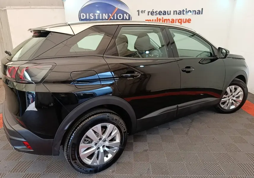 Vue 3/4 arrière droite d’un Peugeot 3008 noir 2022 avec jantes alliage et vitres teintées en intérieur showroom.