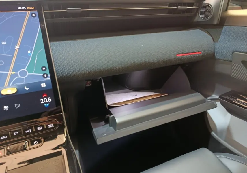 Intérieur de la Citroën C5 Hybride 2026, vue côté passager sur la boîte à gants ouverte et écran tactile central.