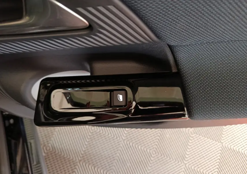 Détail de la commande électrique de lève-vitre sur la porte intérieure côté gauche d'une Citroën C5 hybride noire.