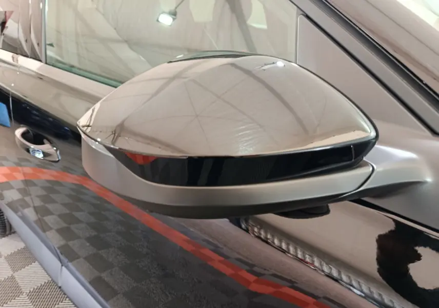Rétroviseur côté gauche noir brillant de Citroën C5 Hybride 2026 avec surface lisse et reflet intérieur.