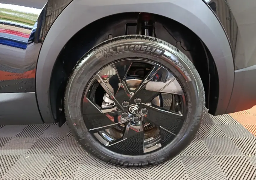 Gros plan sur la roue avant gauche noire brillante d'une Citroën C5 Hybride 2026 avec jante stylisée et pneu Michelin.
