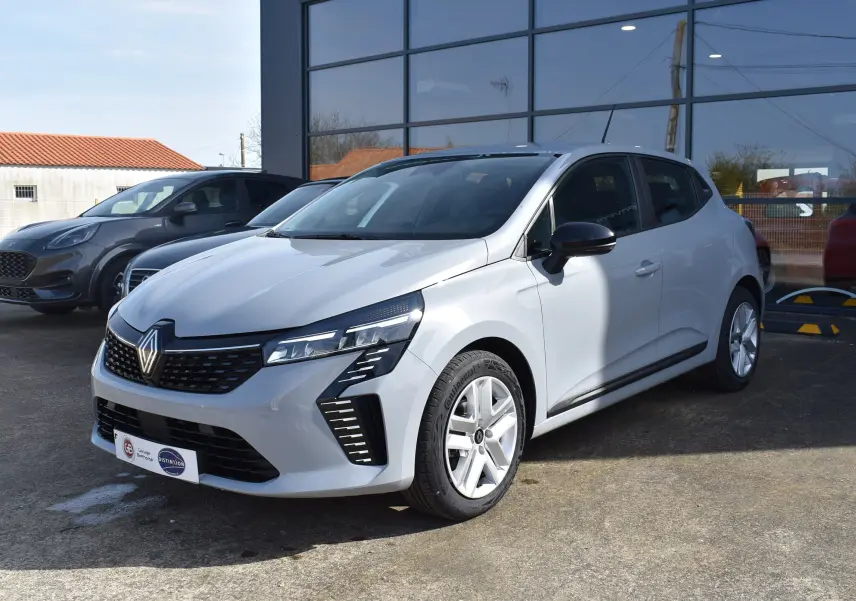 Renault Clio V gris vue 3/4 avant droit, mettant en valeur ses phares LED et sa calandre noire distinctive.