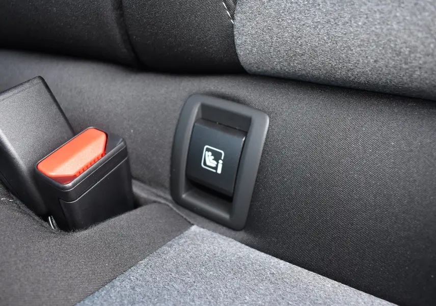 Gros plan sur la boucle de ceinture et l'ancrage ISOFIX arrière d'une Renault Clio V gris tissu.