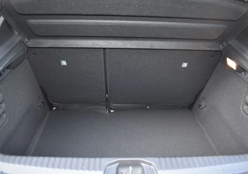 Coffre ouvert de la Renault Clio V TCE 90 gris, montrant l'espace de chargement intérieur vide et bien éclairé.