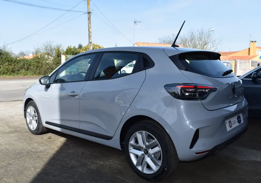 Vue 3/4 arrière droite d'une Renault Clio V gris clair 2024 avec feux arrière LED et jantes alliage.