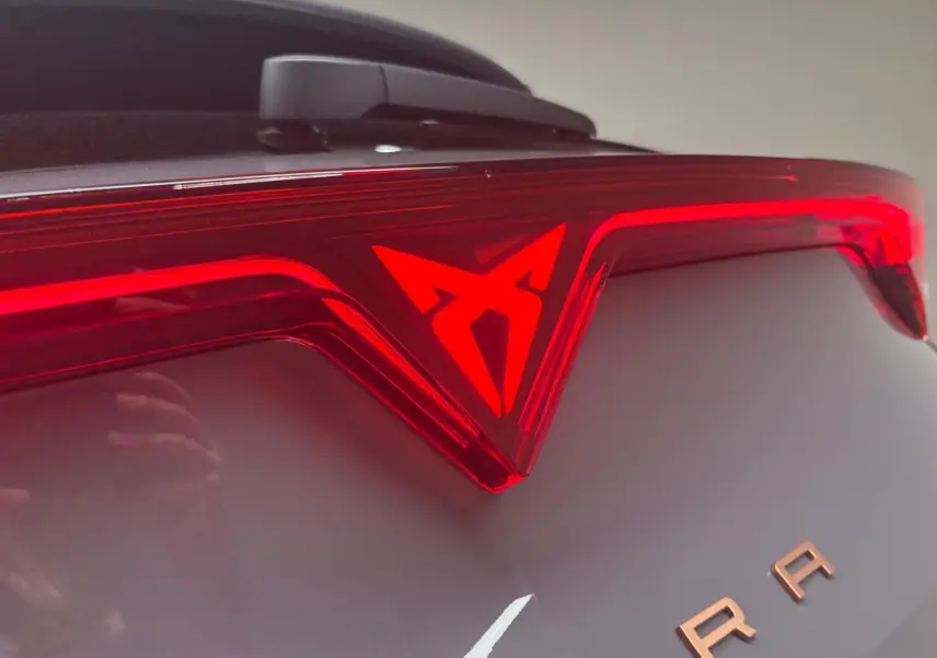 Gros plan sur le feu arrière rouge et le logo CUPRA d'un Formentor gris graphène 2025 avec toit ouvrant.