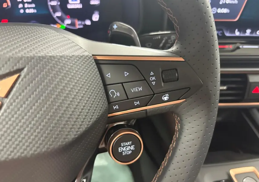Détail du volant perforé du CUPRA Formentor 2025 avec commandes multifonctions et bouton start/stop entouré de cuivre.