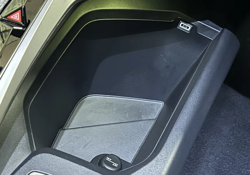 Espace de rangement central noir avec prise USB et allume-cigare dans un Peugeot 3008 2025.