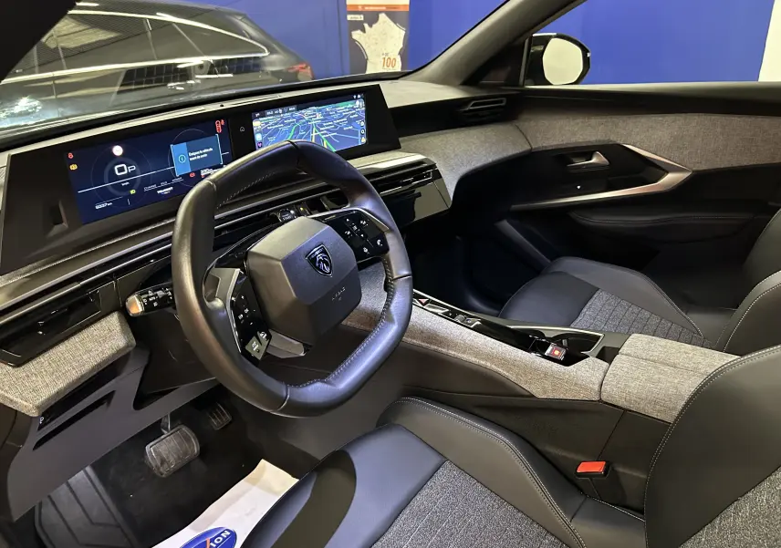 Vue intérieure côté conducteur du Peugeot 3008 Hybrid 2025, avec volant compact et tableau de bord numérique moderne.