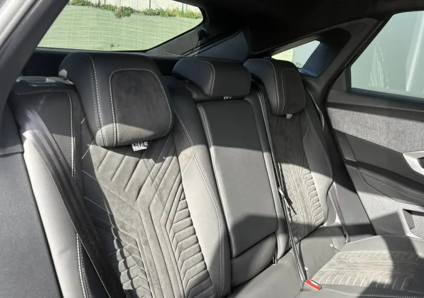 Vue intérieure des sièges arrière en Alcantara noir avec surpiqûres blanches du Peugeot 3008 Hybrid 2025.