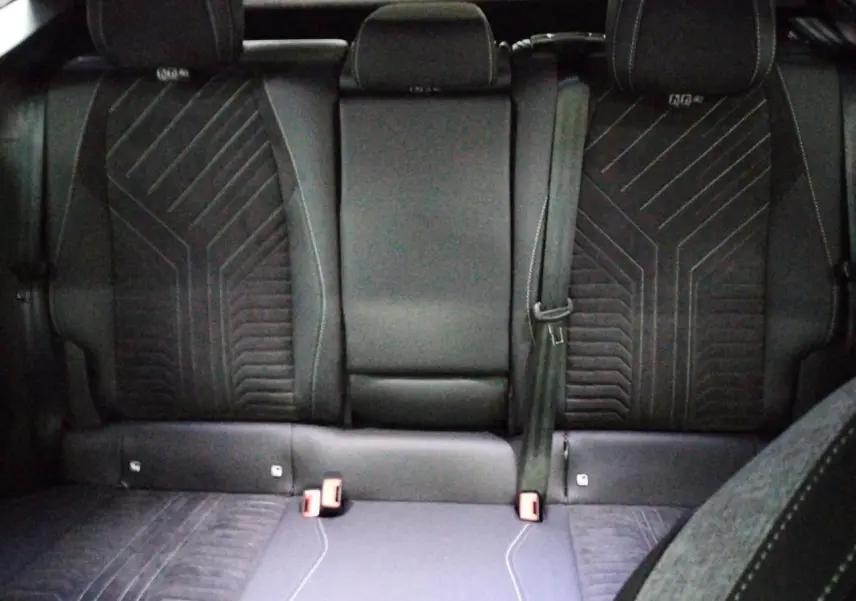 Vue rapprochée des commandes électriques de réglage du siège conducteur sur la porte intérieure noire du Peugeot 3008 Hybrid 2025.