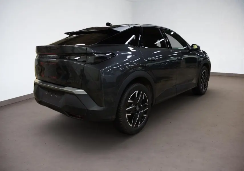 Volant compact cuir perforé noir avec badge GT au centre, tableau de bord et commandes tactiles du Peugeot 3008 Hybrid 2025.