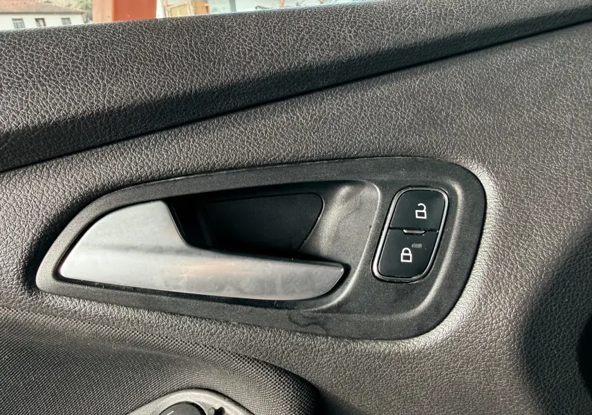 Vue rapprochée de la console centrale intérieure grise de la Ford Focus 1.5 TDCI 120 ST Line, avec frein à main et porte-gobelets.
