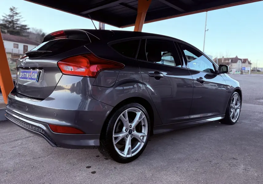 Vue 3/4 arrière droite d'une Ford Focus gris métallisé 5 portes, avec jantes alliage et toit noir contrasté.