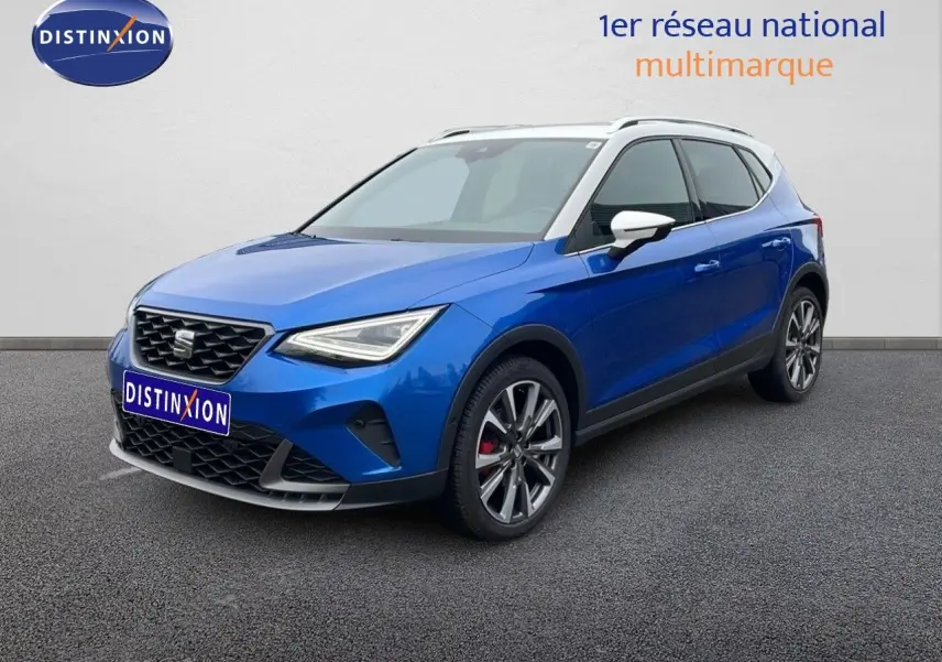SEAT Arona bleu saphir métal avec toit blanc, vue 3/4 avant droit, jantes alliage et calandre distinctive.