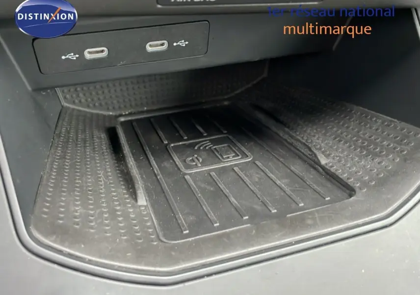 Gros plan sur la zone de recharge sans fil et ports USB dans l'habitacle du SEAT Arona 2025.
