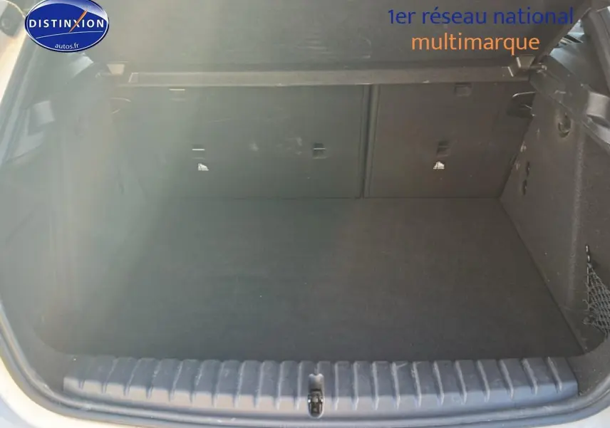 Coffre ouvert vu de l'arrière d'une BMW Série 1 blanche, espace de chargement propre et spacieux.