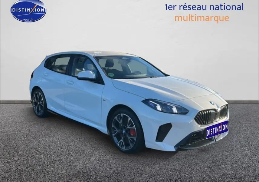 BMW Série 1 blanc alpin vue 3/4 avant droit avec jantes 18 pouces bicolores et calandre M sport.
