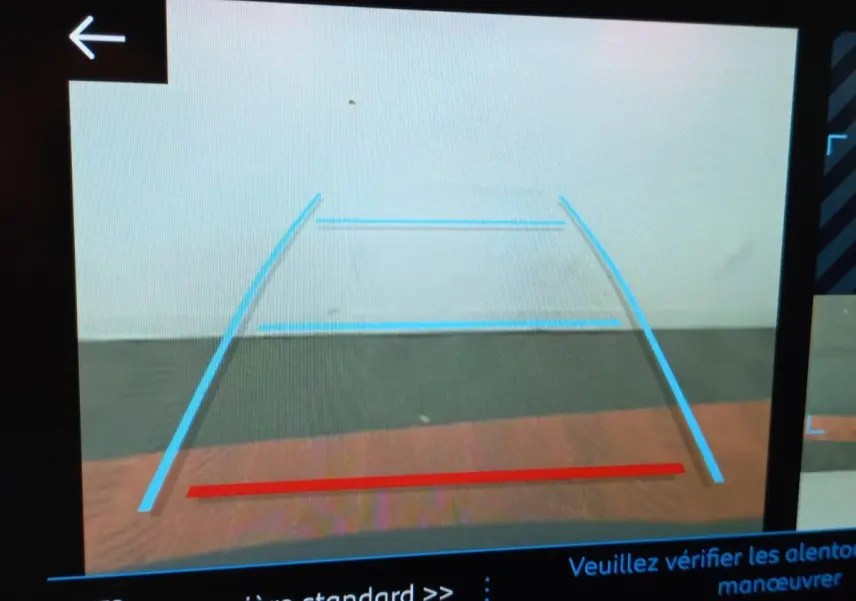 Vue arrière caméra de recul du Peugeot 3008 noir, affichant les lignes de guidage bleues et rouge sur écran.