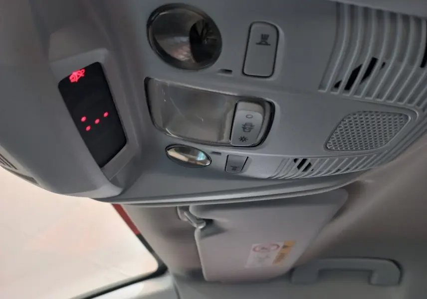Vue intérieure en gros plan du plafonnier gris avec commandes d’éclairage et alerte ceinture du Peugeot 3008 noir 2022.