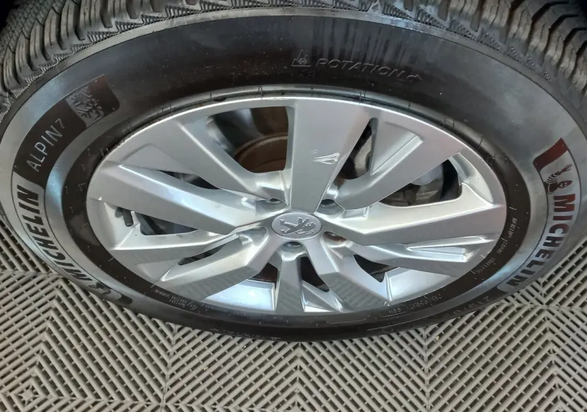 Gros plan sur la jante alliage argentée et le pneu Michelin d’un Peugeot 3008 noir, vue latérale.