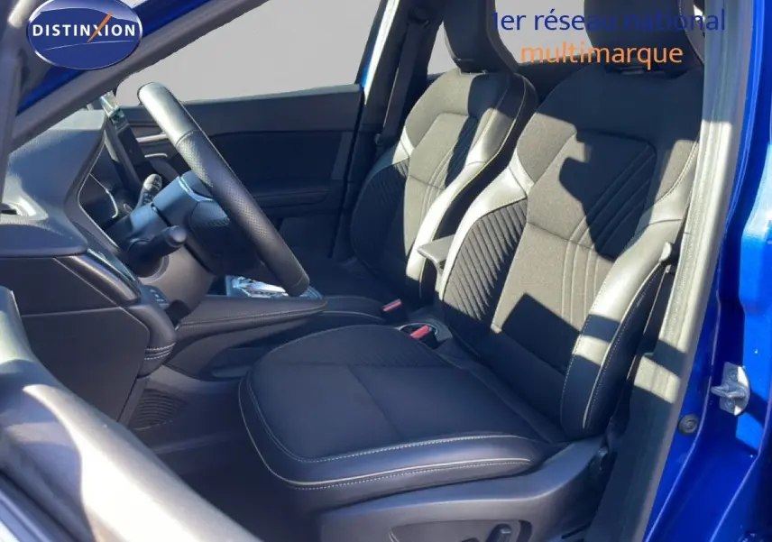 Vue intérieure côté conducteur de la Renault Symbioz 2025 bleu iron metal, sièges tissu noir avec surpiqûres blanches.