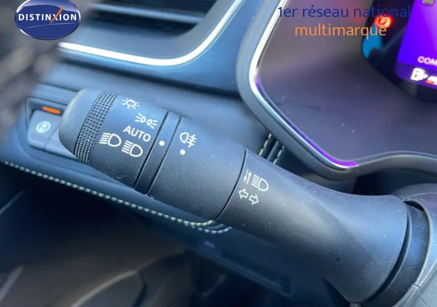 Gros plan sur la commande des phares et clignotants dans l’habitacle noir du Renault Symbioz bleu Iron Metal.
