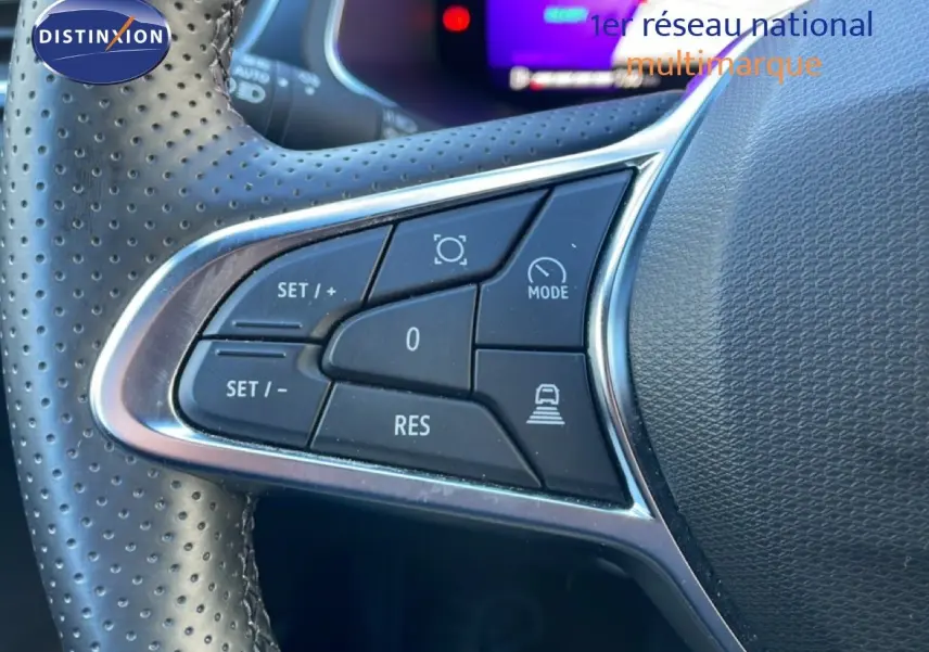 Gros plan sur les commandes au volant en cuir perforé du Renault Symbioz bleu iron metal, version hybride 2025.